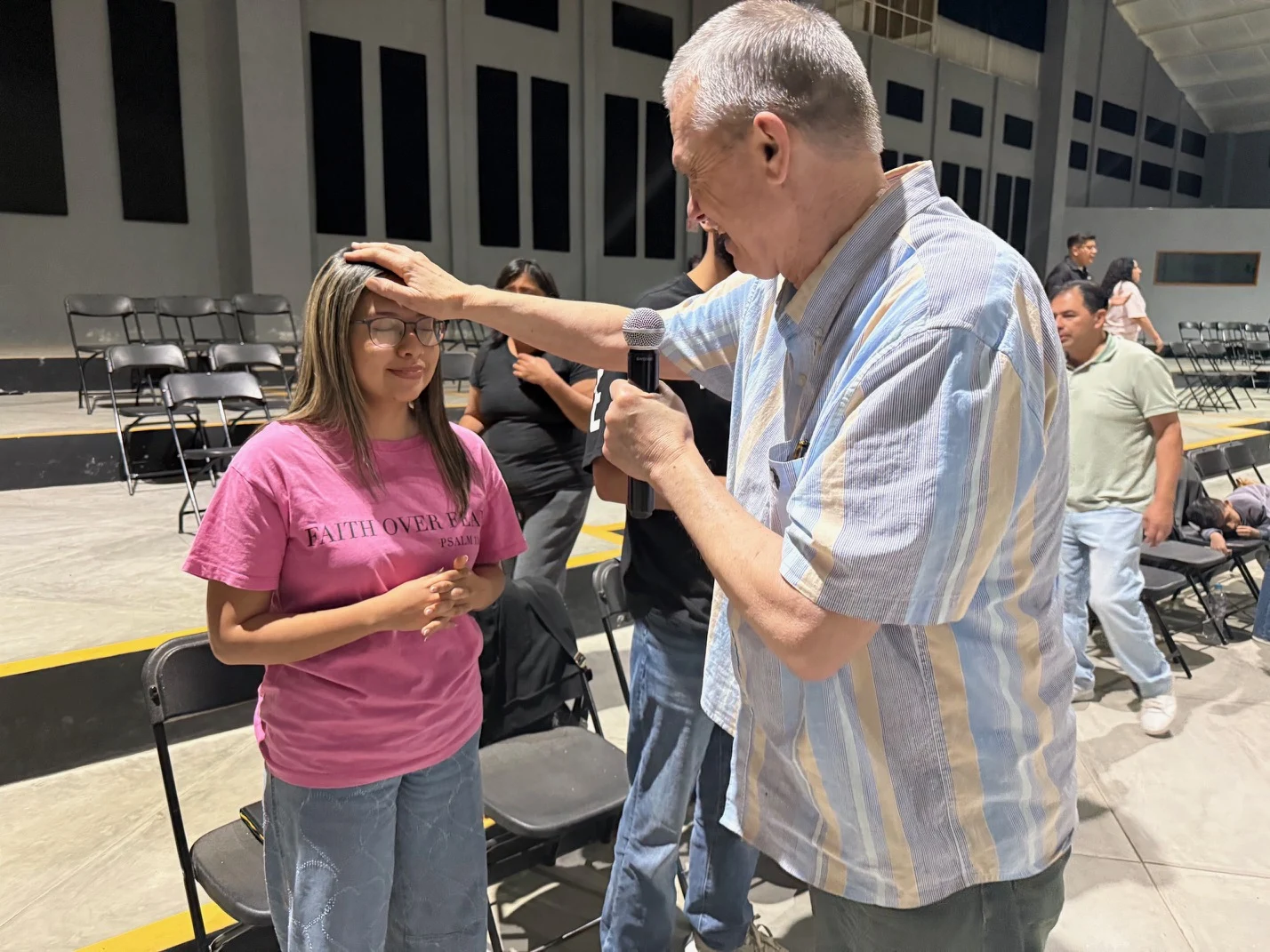 Terry praying with a woman at a ministry gathering